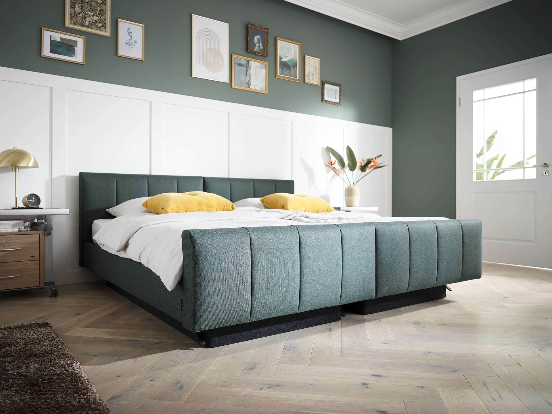 Modernes Schlafzimmer mit komfortablem Bett, grüner Wand, Wandbilder und natürlichem Licht, ideal für erholsamen Schlaf.