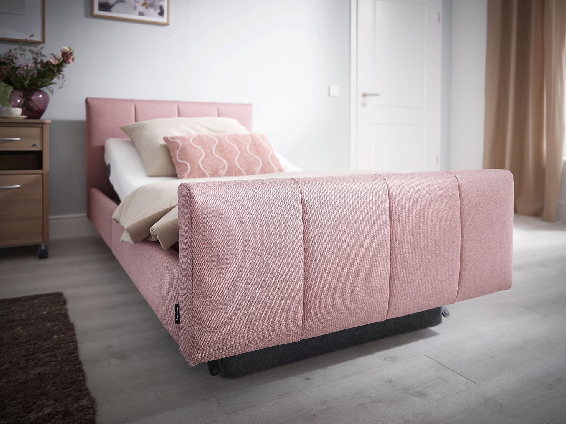 Modernes, pinkfarbenes Bett im Schlafzimmer bei Bettenhaus Schlafoase Nürnberg, mit bequemer Matratze und stilvollem Design.