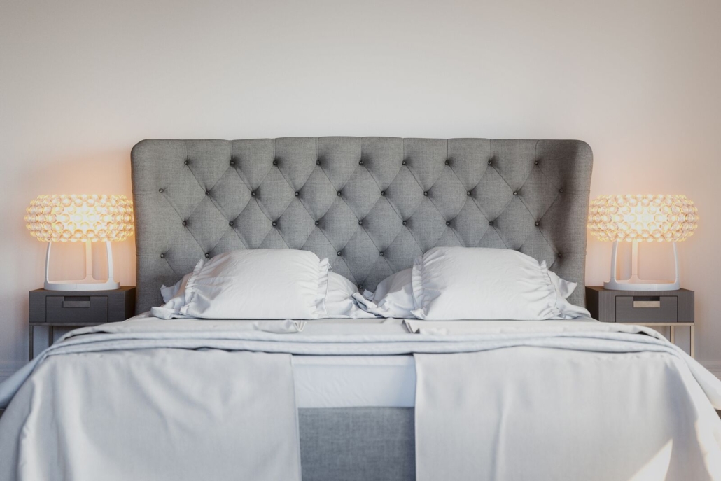 Bett mit gepolstertem Kopfteil und Nachttischlampen
